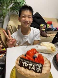 誕生日ケーキとピースをする子供